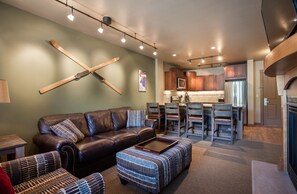 Relax in a stylish living space with a sofa, ottoman, and coffee table, plus a convenient dining area and kitchen.