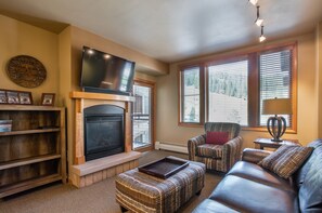Cozy living room with a fireplace, comfortable seating, and a TV.
