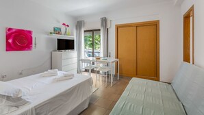Ett hotellrum med en säng, ett skrivbord, en tv och en garderob.