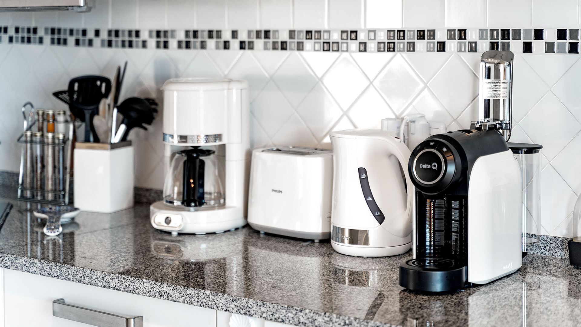 A kitchen with a coffee maker, toaster, and blender on the counter.