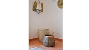 A corner of a room with two woven baskets on the floor and a woven basket hanging on the wall. - 2BR  Duplex Townhouse w/Pool by LovelyStay (Ferragudo)