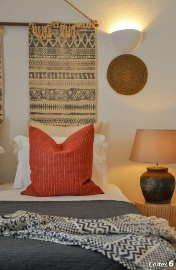 A bedroom with a bed, pillows, a lamp, and a wall hanging. - 2BR  Duplex Townhouse w/Pool by LovelyStay (Ferragudo)