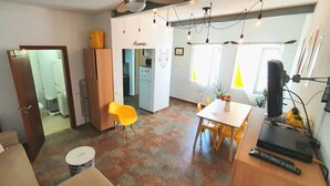 En kompakt bolig med spiseplads, køkken og et lille badeværelse.