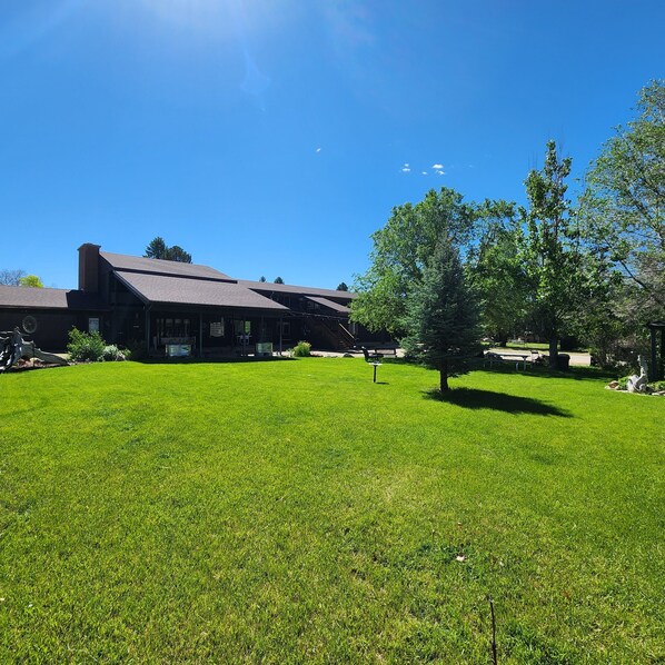 A large building with a sloped roof and a well-maintained lawn in front.
