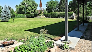 A well-maintained lawn with a stone birdbath, a statue, and a sign for Carter Inn. - The Carter inn (Ten Sleep)