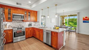 Una cocina moderna con armarios de madera, electrodomésticos de acero inoxidable y una isla grande.