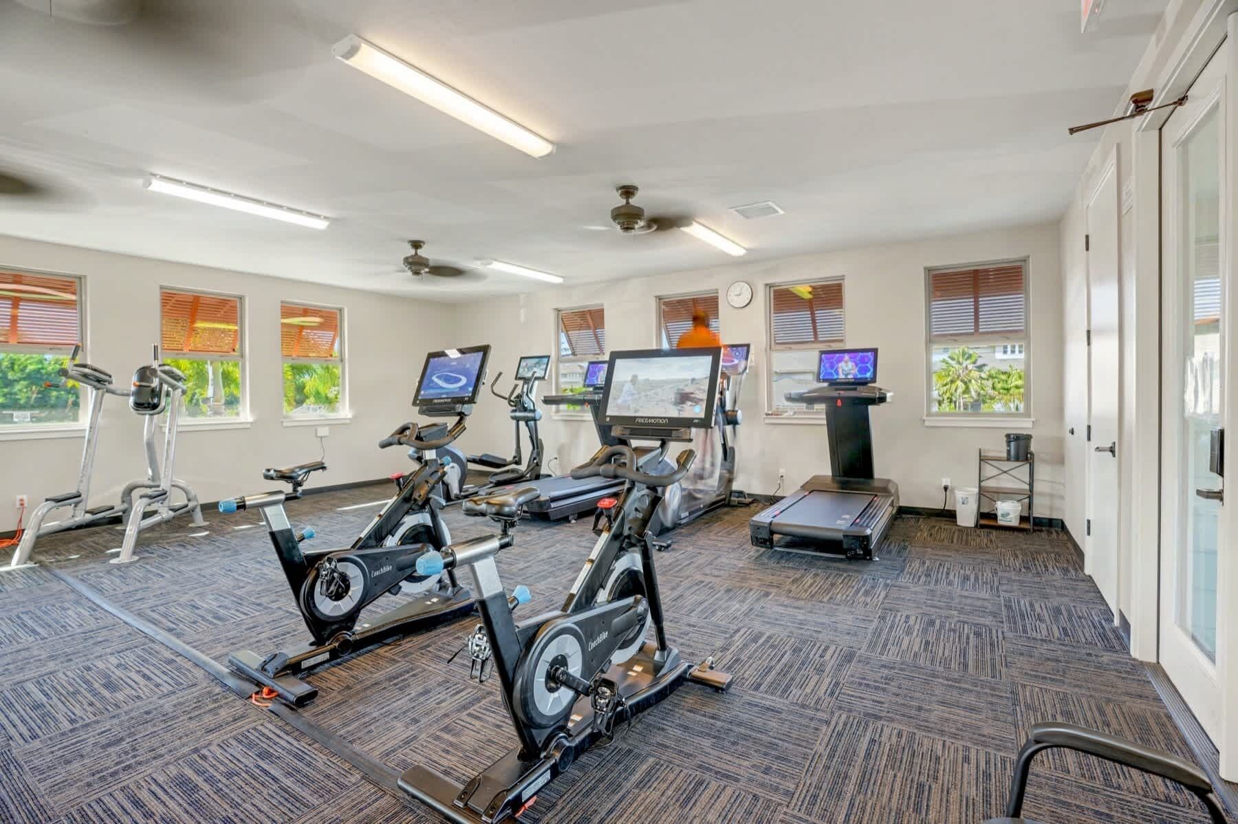 A gym with stationary bikes, treadmills, and exercise equipment.