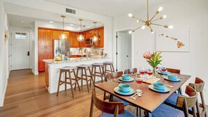 Una cocina moderna con armarios de madera, una isla central e iluminación colgante.