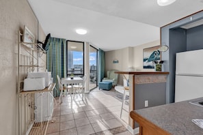Enjoy a homey atmosphere in this cozy space, featuring a kitchenette, dining area, and balcony with city views.