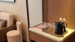 A small kitchenette with a coffee maker, glasses, and a tray. - Shihaolou Hotel (Gejiu)