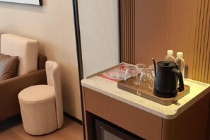 A small kitchenette with a coffee maker, glasses, and a tray. - Shihaolou Hotel (Gejiu)