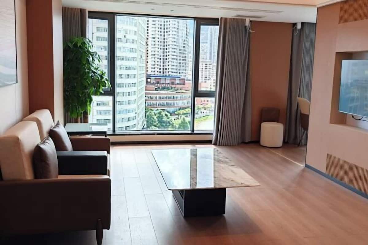 A modern living room with a sofa, a coffee table, and a TV.