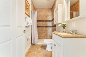 A bathroom with a shower, toilet, and sink.