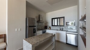 Una cocina moderna con encimeras de granito, electrodomésticos de acero inoxidable y horno integrado.