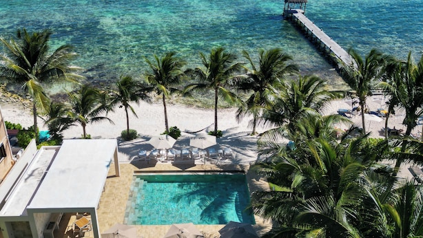 Un resort con piscina, playa y muelle.