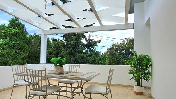 An outdoor patio with a table and chairs, a potted plant, and a view of trees. - [Panorama] View and Comfort a few steps away from the beach (Orosei)
