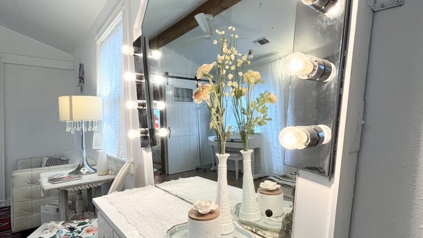 Een badkamer met een wastafel, spiegel en verlichting.
