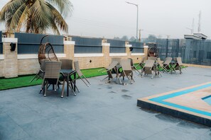 Una piscina al aire libre, sombrillas, sillones reclinables de piscina