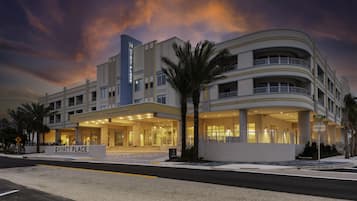 A multi-story hotel with a prominent entrance, a sign reading "HYATT PLACE," and a palm tree in front.