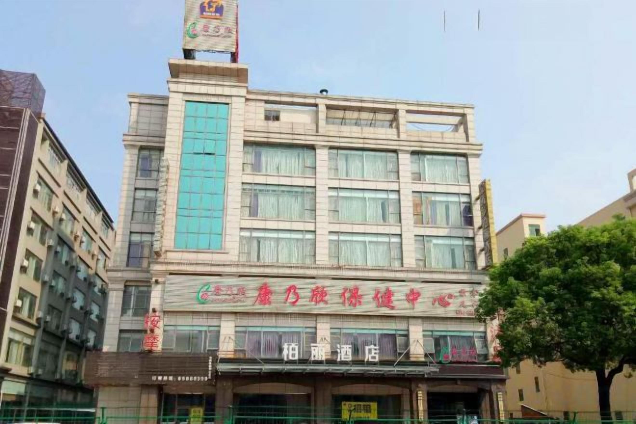 Un edificio de varios pisos con un letrero llamativo en la parte superior.