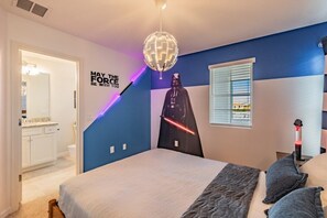 A bedroom with a Star Wars theme, including a Darth Vader poster, a globe light, and a motivational quote on the wall.