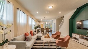 A modern living room with a sofa, armchairs, a coffee table, and a striped rug.