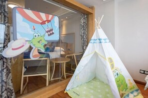 A room with a glass partition, a small table, a chair, and a tent with cartoon characters. - Yitu Lake View Hotel (Chun'an)