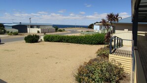 Un quartier résidentiel avec une allée en gravier, un petit jardin et une vue sur la mer.