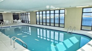An indoor swimming pool with clear windows, a tiled deck, and a view of the sea. - Huge Balcony with Direct Gulf View!  Watch the boats in the Pass!  Wifi (Orange Beach)