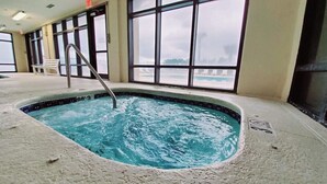 An indoor swimming pool with a metal ladder, large windows, and a bench. - Huge Balcony with Direct Gulf View!  Watch the boats in the Pass!  Wifi (Orange Beach)