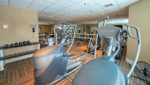 A gym with cardio machines, weights, and mirrors.