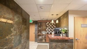 A reception area with a wooden desk, a computer, and a 'Restroom' sign.