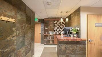A reception area with a wooden desk, a computer, and a 'Restroom' sign.