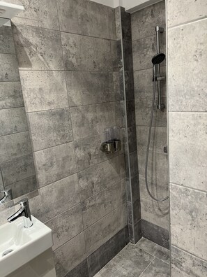Habitación individual panorámica | Baño | Ducha, artículos de higiene personal de diseño y secador de pelo