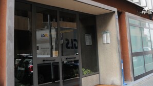 A building with a large glass entrance, a visible parking area, and a sign indicating a scale of 2. - Apartment in Trastevere free wi-fi 1GB/s fiber, AC, equipped kitchen, balcony. (Roma)