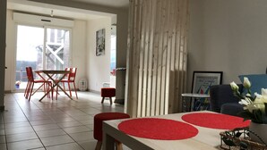A dining area with a wooden table, red chairs, and a red rug. There is a wooden partition and a framed picture on the wall. - Charming apartment, Left bank (Rouen)