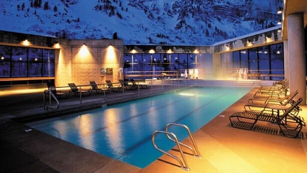 A pool area with lounge chairs and a view of snow-covered mountains at dusk. - Cliff Lodge Snowbird  Ski In/Ski Out 2 BR, 3 bath, sleeps 10, 12/31 - 1/7  (Sandy)