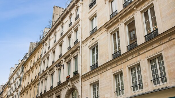 A row of classical European buildings with uniform facades, large windows, and balconies. - Appartement des Bergères - Welkeys (Paris)