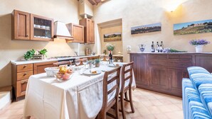 A dining area with a table set for four, wooden cabinets, a kitchen area, and a view of the countryside through a skylight. - Apartment in a historic Villa _"FORIPORTA"_view & authentic hospitality in Siena (Siena)