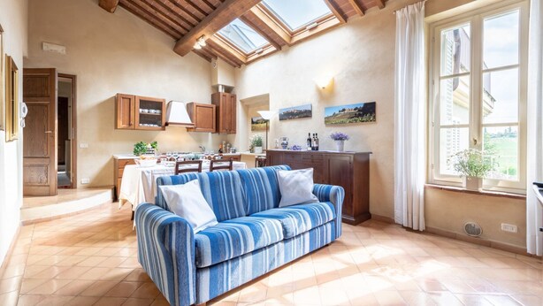 A spacious living area with a sofa, dining table, and kitchen in the background. - Apartment in a historic Villa _"FORIPORTA"_view & authentic hospitality in Siena (Siena)
