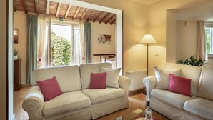 Una sala de estar con dos sofás, una lámpara y vistas al exterior.