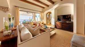 Una sala de estar amplia con un sofá grande, un comedor y una televisión.