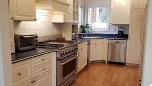A kitchen with white cabinets, a stove, a microwave, and a dishwasher.
