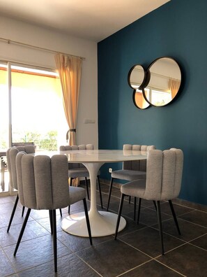 Un'area pranzo moderna con un tavolo rotondo e sedie rivestite in grigio.