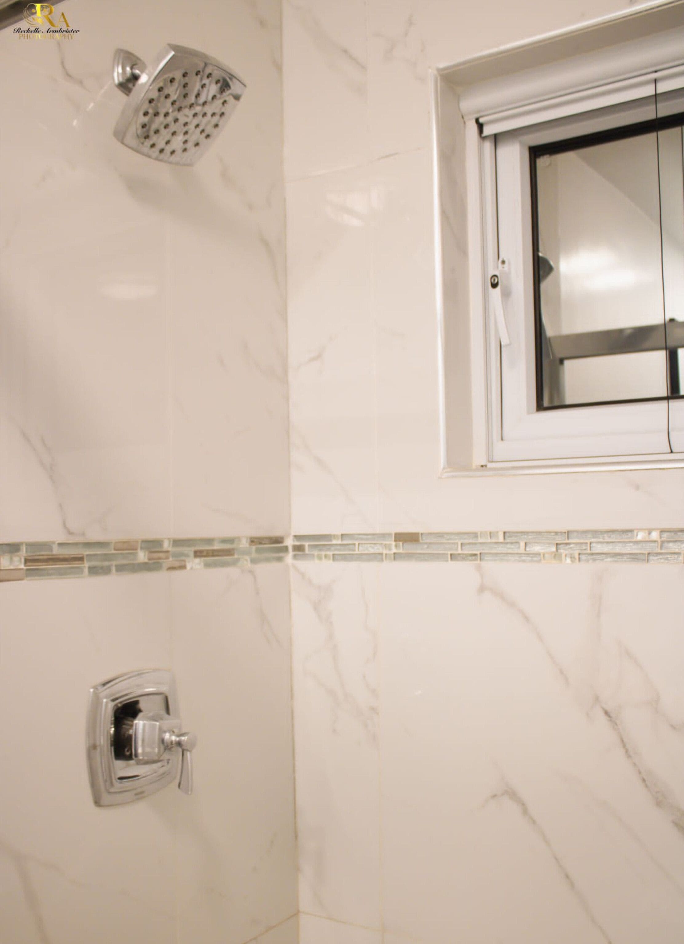 Un baño con ducha, inodoro y ventana con vistas al exterior.