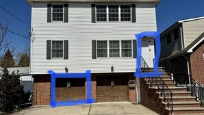 Ein zweistöckiges Haus mit Garage und Ziegelveranda.