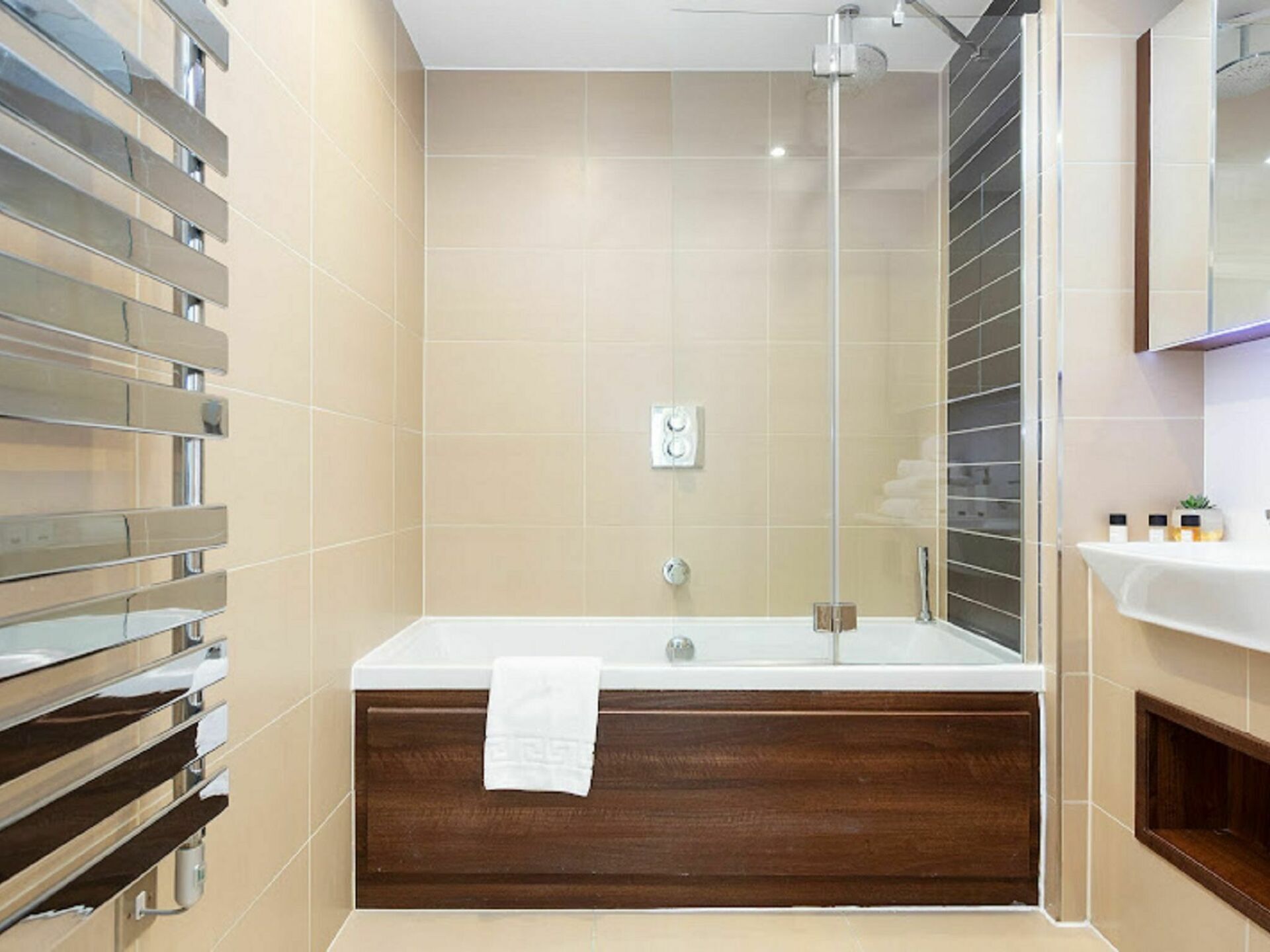 A modern bathroom with a large bathtub, a glass shower enclosure, and a wooden vanity.