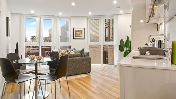 A modern apartment with a dining area, kitchen, and large windows offering city views. - Cosy apartment for 2 guests with WIFI and TV (London)