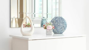 A white dresser with a mirror above it, a white handbag, a blue and white vase with flowers, and a blue and white patterned vase. - Cosy apartment for 2 guests with WIFI and TV (London)