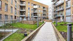 A modern apartment building with a brick facade, multiple balconies, and a central pathway. - Nice apartment for 4 guests with WIFI, TV and balcony (London)